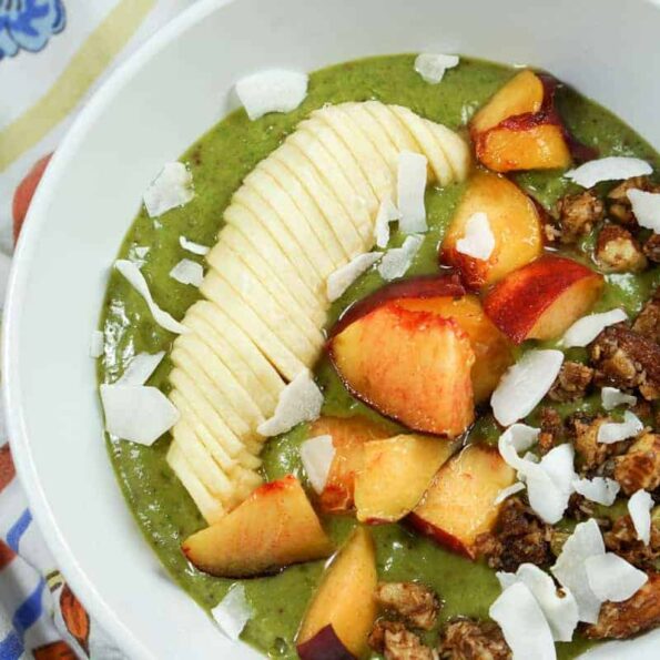 Peaches n Kale Smoothie Bowl Recipe - A delicious peaches n' cream smoothie bursting with antioxidants and protein. Topped with fruit and wholesome granola, it's a perfect way to start the day or treat yourself at night.