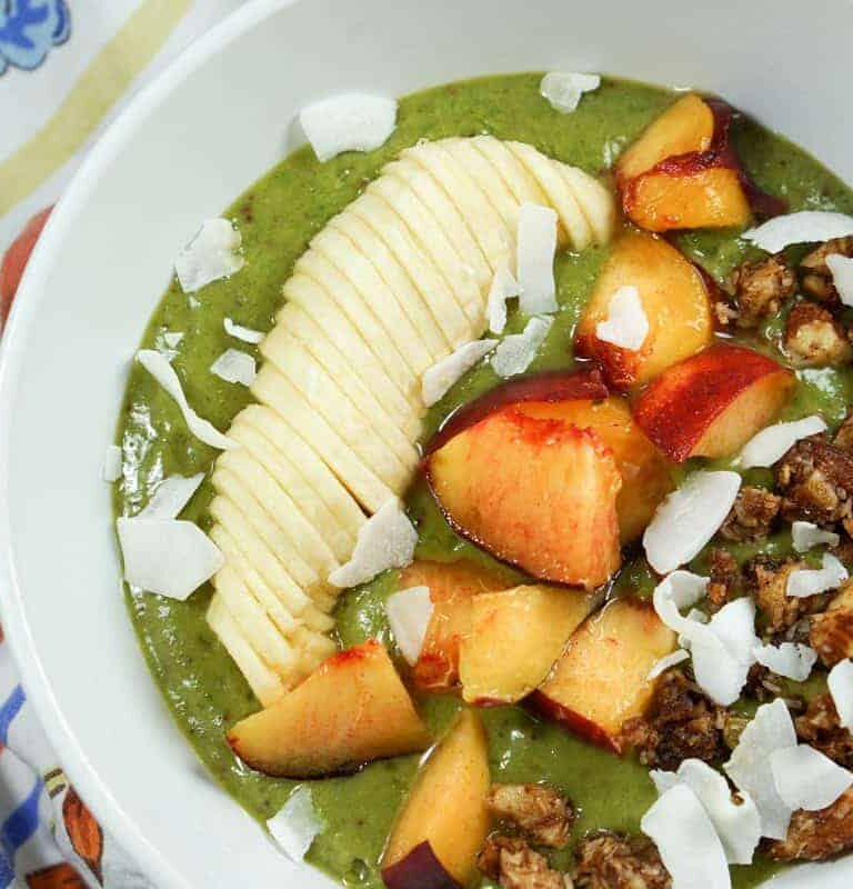 Peaches n Kale Smoothie Bowl Recipe - A delicious peaches n' cream smoothie bursting with antioxidants and protein. Topped with fruit and wholesome granola, it's a perfect way to start the day or treat yourself at night.