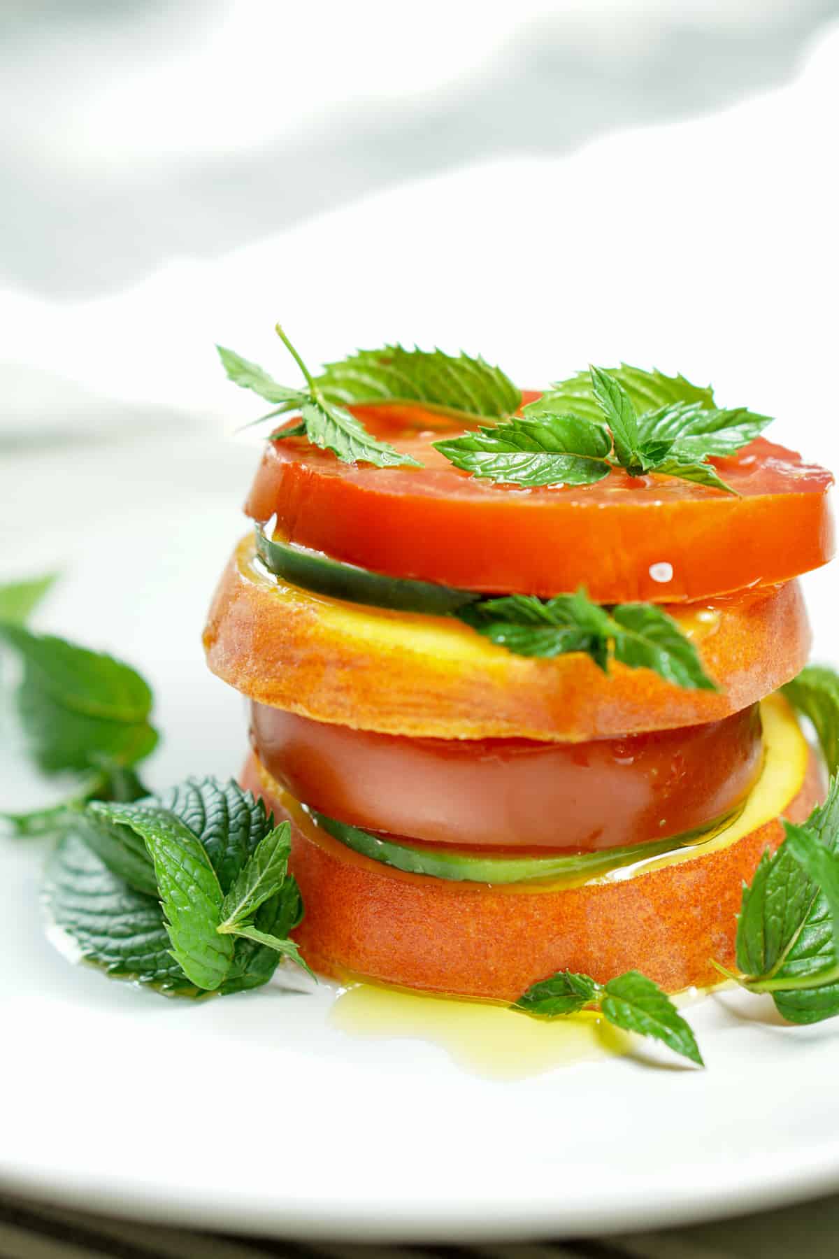Peach Tomato Mint Salad Stack Recipe - Simply slice fresh peaches, tomatoes and cucumbers, stacking with mint to create this great appetizer, light meal or side salad. This will definitely be a recipe to impress your friends at your next barbq or family dinner!