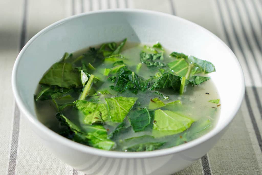 Try this nourishing bone broth over winter greens recipe is a quick and healthy meal that will reset your body after overindulging. Healthy + Delicious