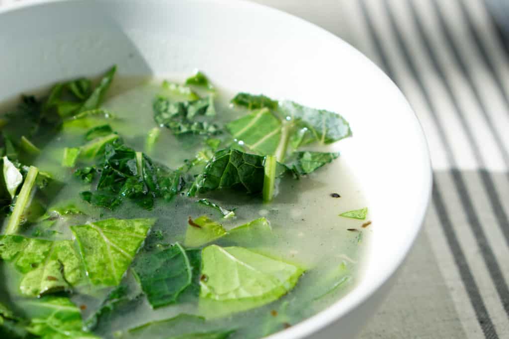 Try this nourishing bone broth over winter greens recipe is a quick and healthy meal that will reset your body after overindulging. Healthy + Delicious