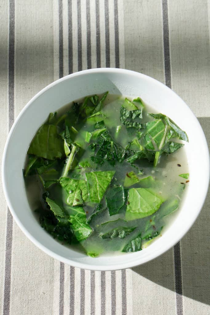 Try this nourishing bone broth over winter greens recipe is a quick and healthy meal that will reset your body after overindulging. Healthy + Delicious