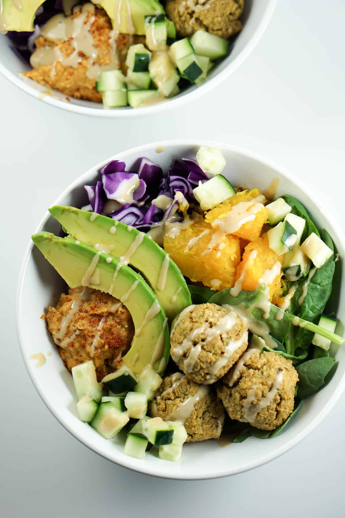 A savory alternative to salad, these quick and easy Falafel Bowls with roasted squash, avocado and harissa hummus recipe make a perfect healthy dinner.