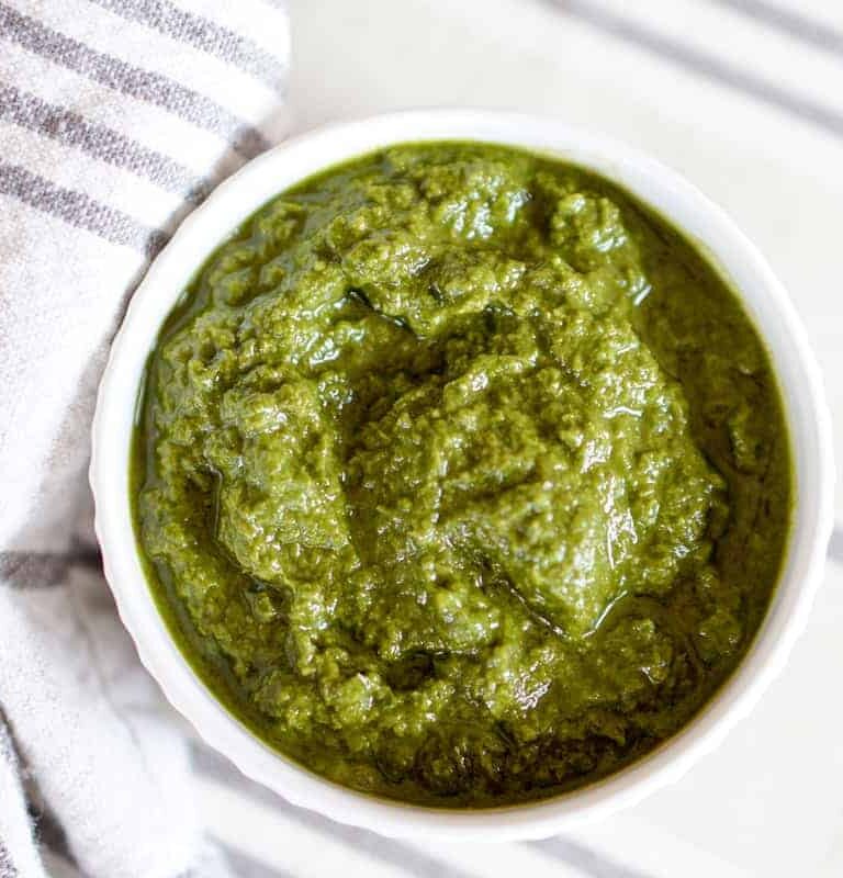 This Awesome Kale Green Sauce recipe is packed with delicious nutritious greens. 5 ingredients, 5 minutes. Use for a healthy kick on Pizza, Salads, + fries.