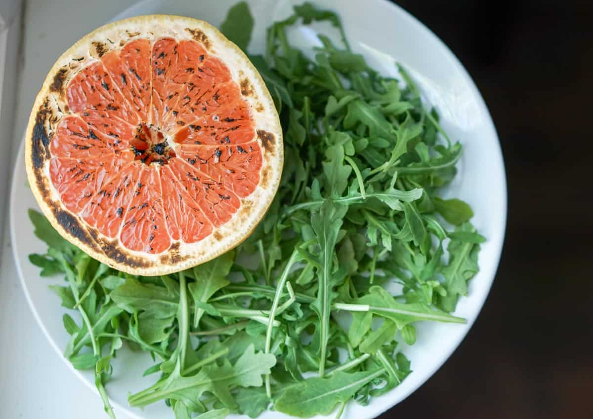 This brûléed grapefruit recipe showcases caramelized sugars without added refined sugars and cream. Add tossed arugula for a paleo, whole 30, GF, DF lunch.