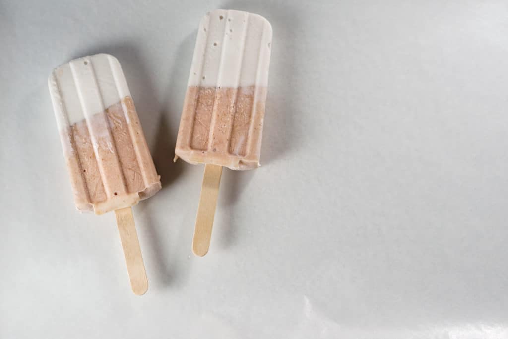 Fresh rhubarb and coconut cream are sweetened with dates and maple syrup for this refined sugar free and dairy free Paleo Rhubarb Coconut Popsicles recipe