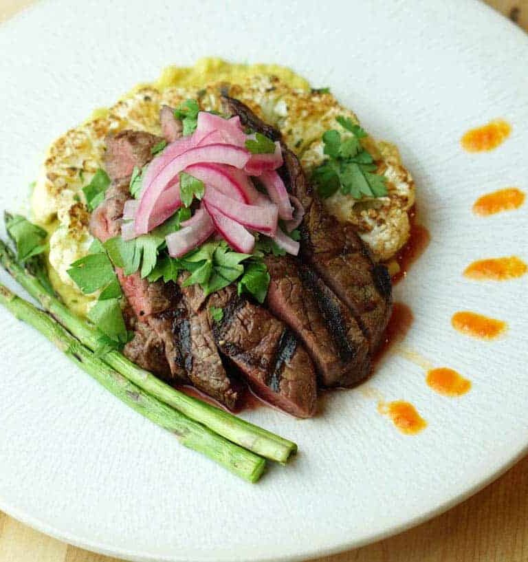 The Deconstructed Steak Taco on Curried Cauliflower Steak recipe merges the flavors of street tacos with Asian cuisine and the traditional steak house: Latin fusion that's healthy, gluten free, grain free and dairy free.