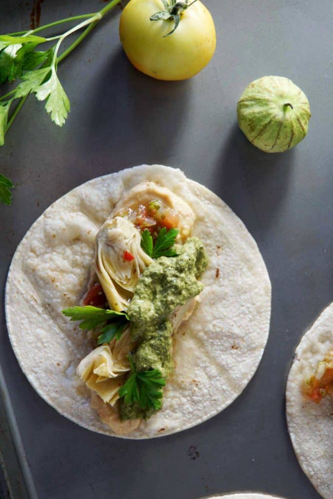 Looking for a healthy meal ready in 5 minutes? Try these Vegan Artichoke Hummus Tacos with Carrot Top Pesto