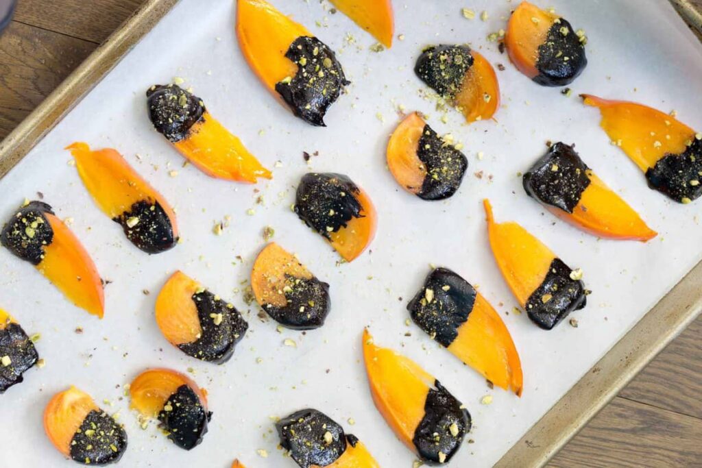 Dip ripe Hachiya or Fuyu persimmons in homemade chocolate sauce and top with crushed pistachios for the easiest dessert to impress.
