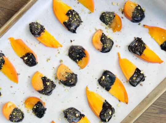 Dip ripe Hachiya or Fuyu persimmons in homemade chocolate sauce and top with crushed pistachios for the easiest dessert to impress.