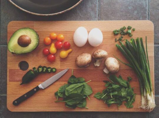 avocado, egg and veggies on a cutting board