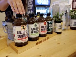 a row of brown glass bottles wit colorful labels for healthade kombucha