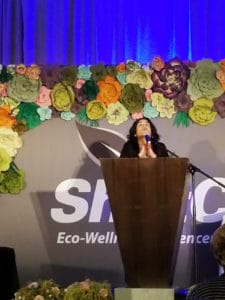 Woman at podium in prayer at Shiftcon position