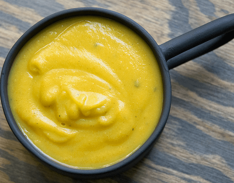 Simple blended 10 minute pumpkin soup with coconut milk and tahini in a black mug. GLuten free, dairy free, whole 30, paleo, and keto