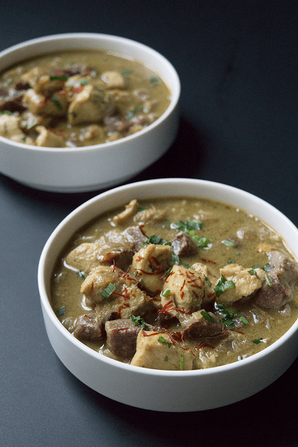 Purple potato halibut curry with cardamom basmati in white bowls on a black background