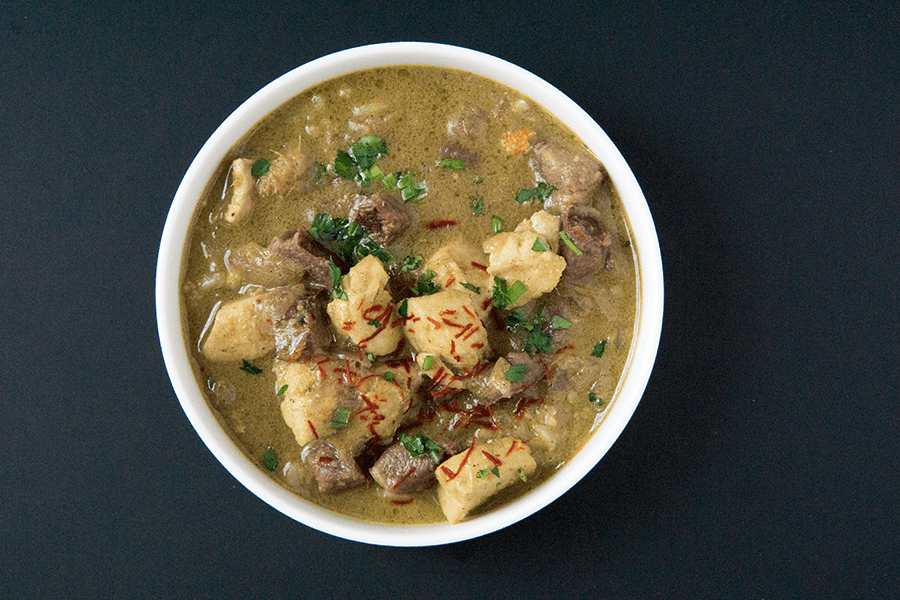 Warming Purple potato halibut curry with cardamom basmati in white bowl on a black background