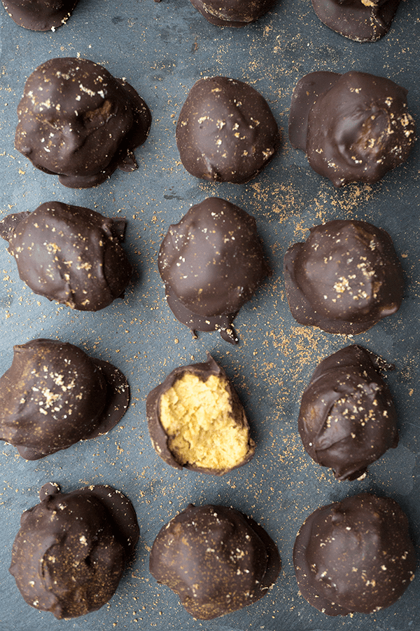 Paleo chocolate covered pumpkin pie bites are rich and creamy, densely packed with health-supporting spices and real pumpkin, stuffed with coconut butter and doused in chocolate.