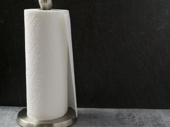 Roll of paper towels on silver paper towel roll on the cement table with black background