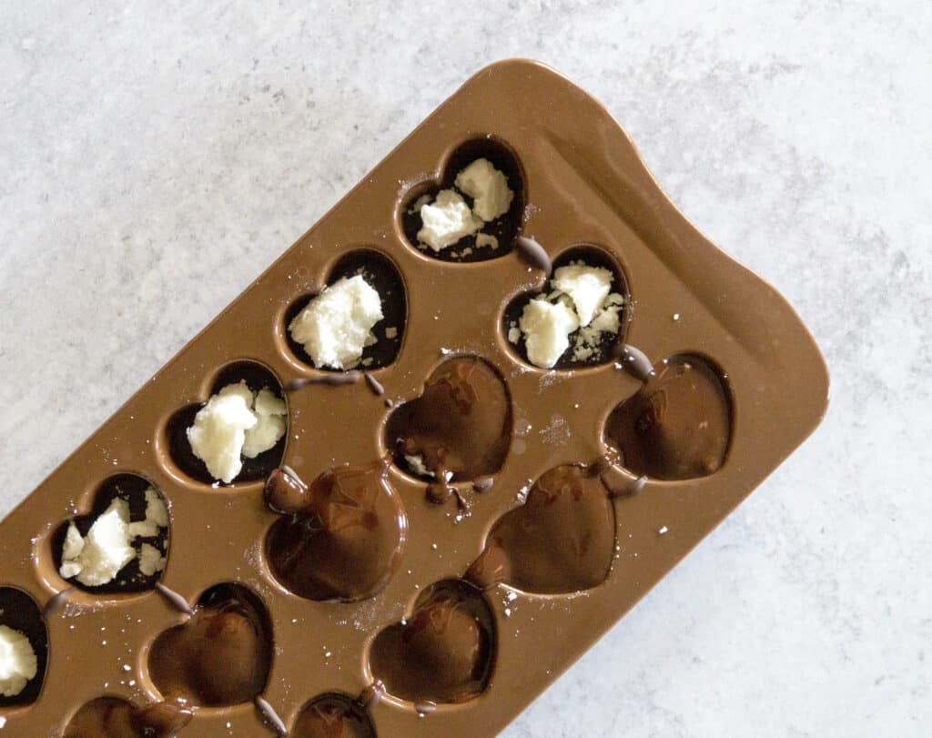 Chocolate covering Coconut Butter Balls in Chocolate Molds