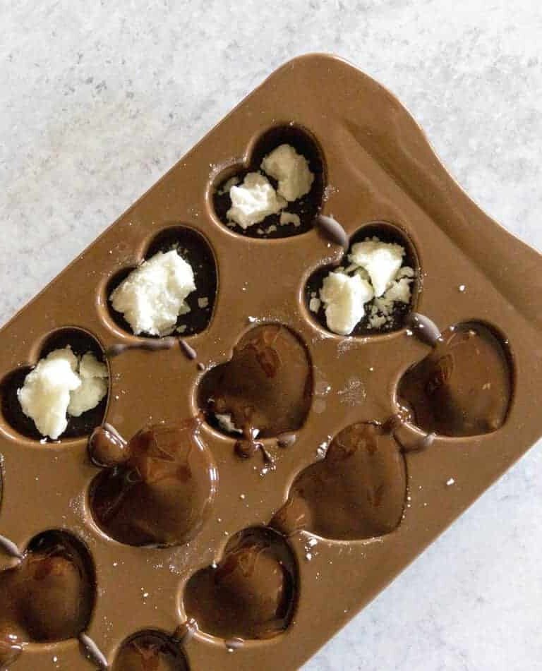 Chocolate covering Coconut Butter Balls in Chocolate Molds