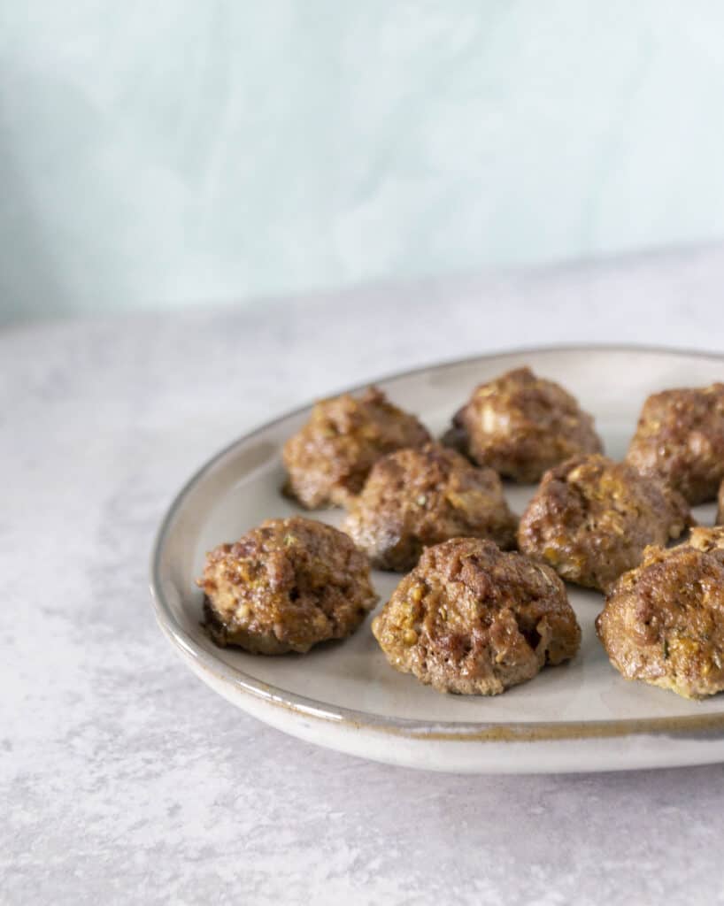 White plate with meatballs on cement surface