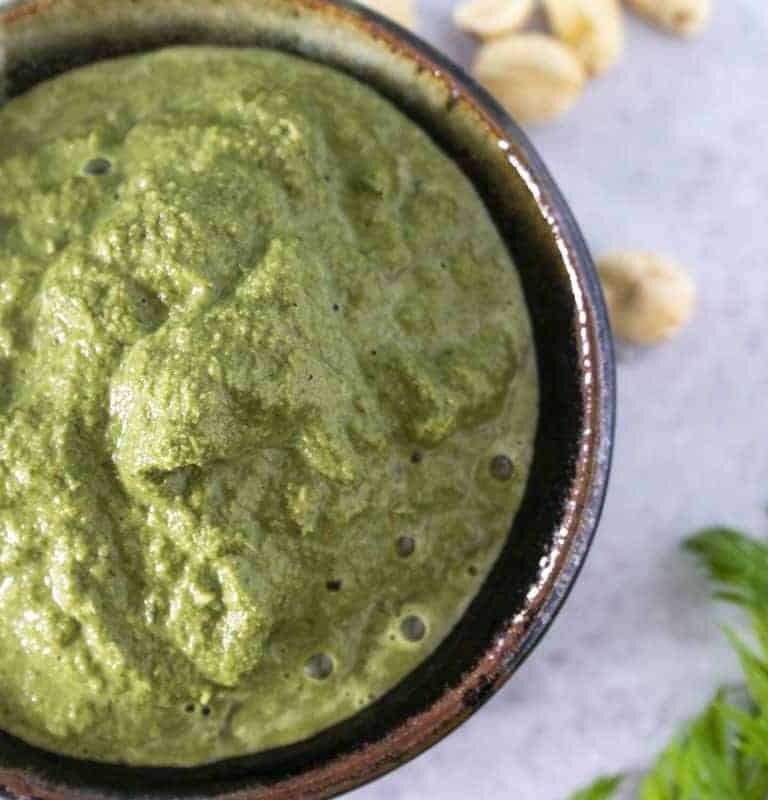 Carrot top pesto in black and white ceramic jar