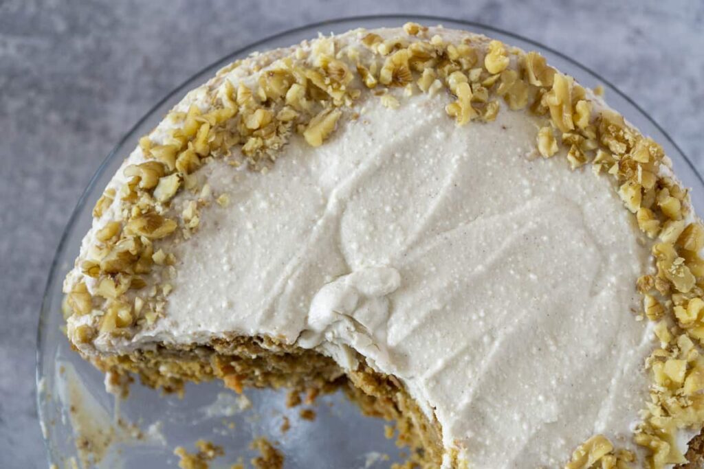 Overhead of ricotta frosted GF carrot cake with crushed walnuts