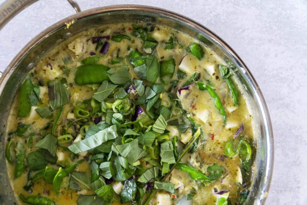 Close up overhead of green curry in copper pan