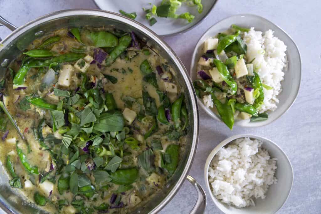Pot of green curry with rice and plated bowl of both