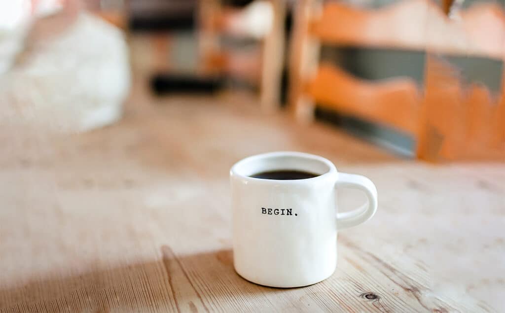 A mug with inscription Begin of coffee on table