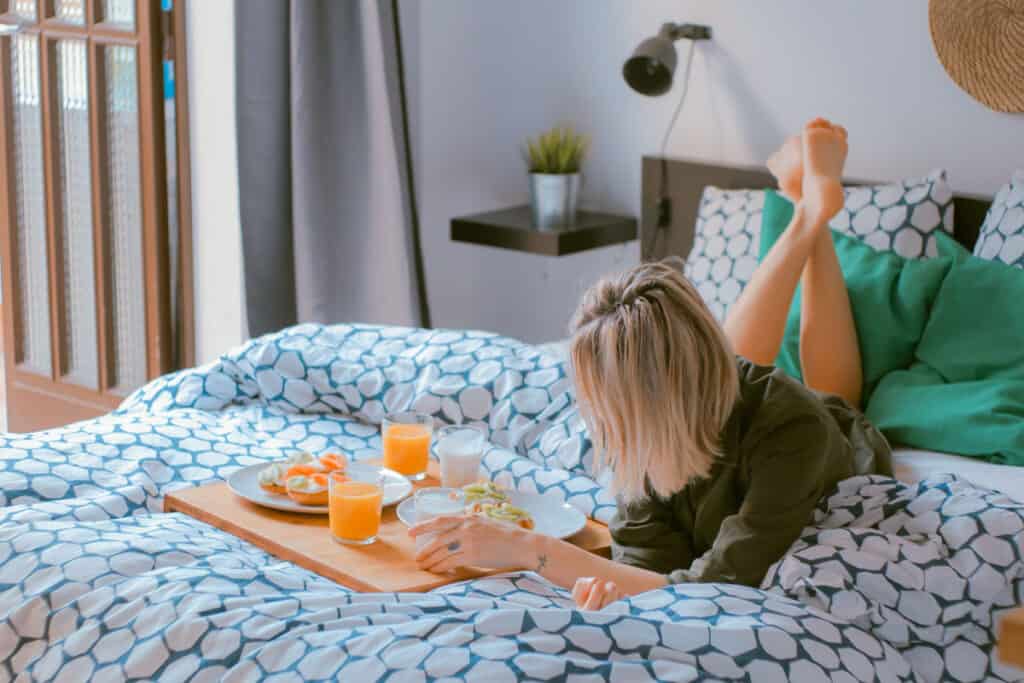 Woman with breakfast in bed journaling